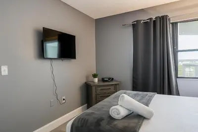 a bedroom with a bed with a television on the wall at 3704 Relax Unwind 2-BD 2-BA Resort Condo in Orlando