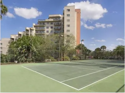 a tennis court in front of a tall building at 3704 Relax Unwind 2-BD 2-BA Resort Condo in Orlando