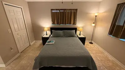 a bedroom with a bed with two lamps and a window at M13 Large Master Room with Private Bathroom & Smart TV in Orlando