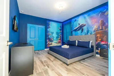 a bedroom with a blue wall with an aquarium at Stunning Masterpiece 15 ensuites in Kissimmee