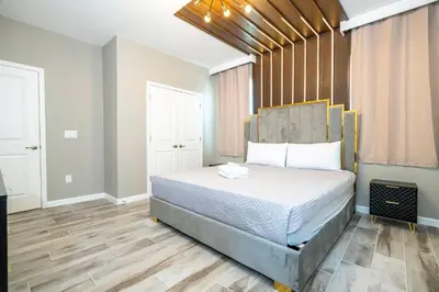 a bedroom with a bed and a wooden floor at Stunning Masterpiece 15 ensuites in Kissimmee