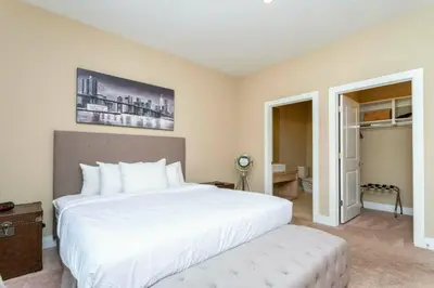 a bedroom with a large white bed and a table at Modern 4bed townhome in the heart of Kissimmee in Orlando