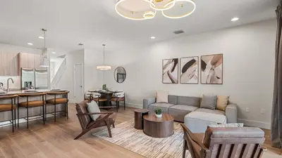 a living room with a couch and a kitchen at Upstay Pristine 3BR Home with Private Pool & BBQ in Orlando