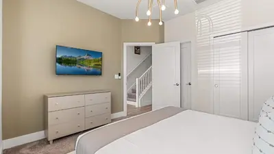 a bedroom with a large bed and a staircase at Upstay Pristine 3BR Home with Private Pool & BBQ in Orlando