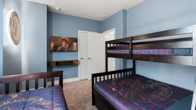 two bunk beds in a room with blue walls at Upstay Pristine 3BR Home with Private Pool & BBQ in Orlando