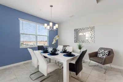 a dining room with a white table and chairs at Gorgeous Waterview ,Top Floor, 2Bd Condo, Storey Lake Resort in Kissimmee
