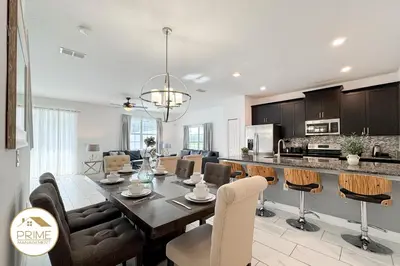 a dining room and kitchen with a table and chairs at New Themed Rooms5BR Near AttractionsResort in Kissimmee