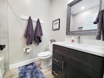 a bathroom with a sink and a toilet and a mirror at Gated 3BR 3BA Townhome Near Disney w Pool and Gym in Orlando