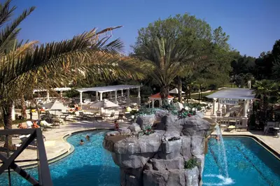 a resort pool with a waterfall and a rock formation at Wyndham Star Island Resort 2BR Apartment with Resort Access in Kissimmee