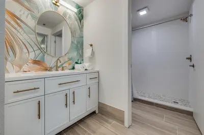 a bathroom with a white vanity and a mirror at Rental near Epic and Universal, free parking in Orlando