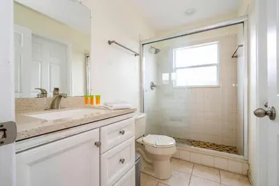 a white bathroom with a sink and a toilet at Amazing 6 bedrooms with pool in Kissimmee