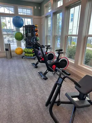 a gym with exercise bikes in a room with windows at Modern Oasis with King Bed, Fireworks View, 10 Minutes to Disney in Orlando