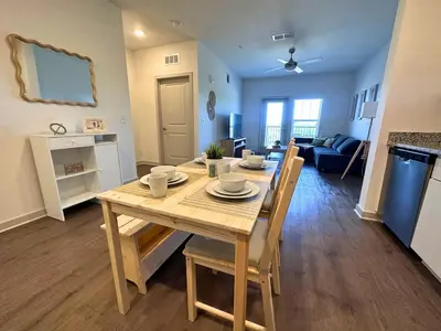 a dining room and living room with a table and chairs at Modern Oasis with King Bed, Fireworks View, 10 Minutes to Disney in Orlando