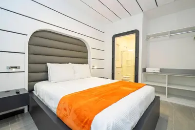 a bedroom with a large bed with an orange blanket at Paradiso Grande 6 bedroom New Home - 10377 in Orlando