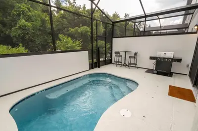 an indoor pool in a house with glass walls at Paradiso Grande 6 bedroom New Home - 10377 in Orlando