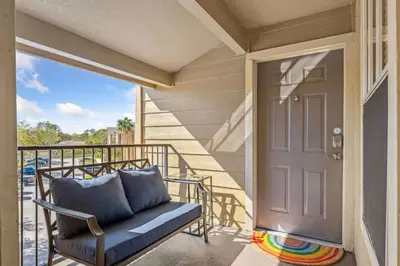 a porch with a blue couch and a door at Adventure's at Villa Del Sol in Kissimmee