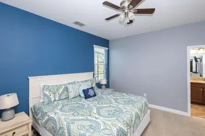 a blue bedroom with a bed and a ceiling fan at Adventurers Oasis - Private pool in Kissimmee
