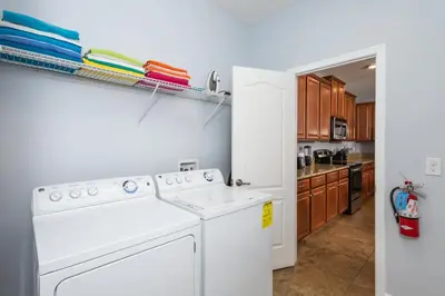 a kitchen with a white washer and dryer at Adventurers Oasis - Private pool in Kissimmee