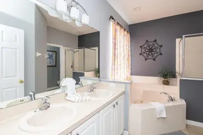 a bathroom with a sink and a tub at Be Our Guest at Emerald Island in Kissimmee