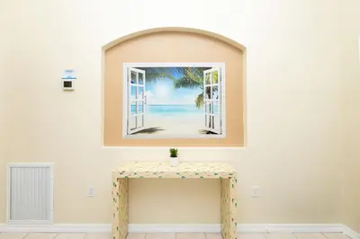 an empty room with a table and an open window at Beachy Retreat in Orlando