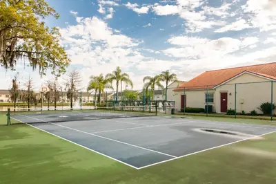 a tennis court in front of a house at Celebrate at Club Cortile in Kissimmee