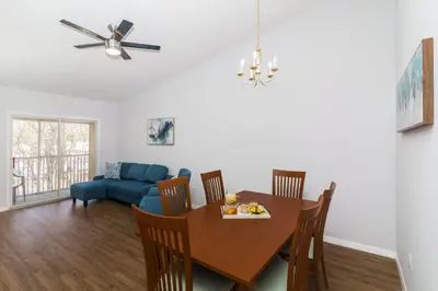 a dining room with a table and a blue couch at Celebrate at Club Cortile in Kissimmee
