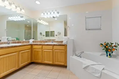 a bathroom with a tub and a large mirror at Cozy Cove - Caribe Escape for 8 in Orlando