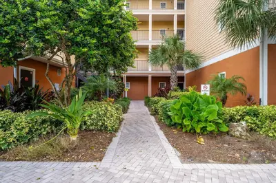 a walkway in front of a building with trees and plants at Cozy Cove - Caribe Escape for 8 in Orlando