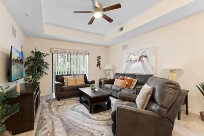 a living room with couches and a ceiling fan at Cozy Cove - Caribe Escape for 8 in Orlando