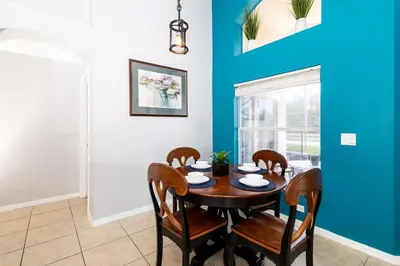 a dining room with a wooden table and chairs at Emerald Island Happy Place in Kissimmee