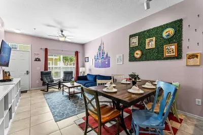 a dining room and living room with a table and chairs at Enchanted At 7 Dwarfs Lane in Kissimmee