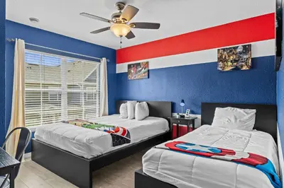 a bedroom with two beds and a ceiling fan at Enchanted At 7 Dwarfs Lane in Kissimmee