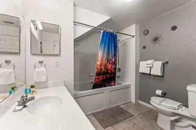 a bathroom with a sink and a toilet and a shower at Enchanted At 7 Dwarfs Lane in Kissimmee