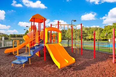 a playground with an orange and blue slide at Enchanted At 7 Dwarfs Lane in Kissimmee
