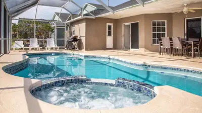 a swimming pool in a backyard with chairs and a table at Wonderland at White Crane - Hot tub & Lake views in Orlando