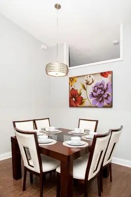 a dining room with a table with chairs and a painting at Wonderland at White Crane - Hot tub & Lake views in Orlando