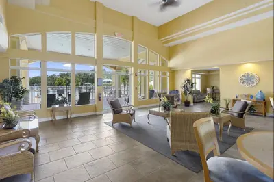 a living room with yellow walls and tables and chairs at Family Friendly Relax Villa in Kissimmee