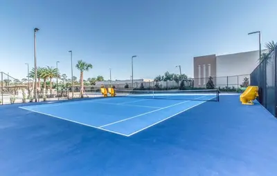 a tennis court with two yellow chairs on it at Villa at Magic Village Resort with Outdoor Oasis in Orlando
