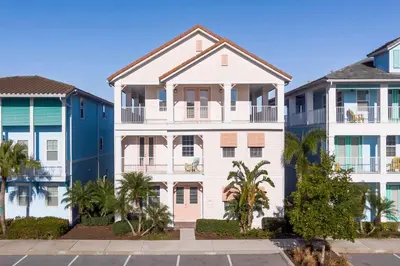 a white apartment building with palm trees in front at Formosa Mimosa - Margaritaville in Orlando