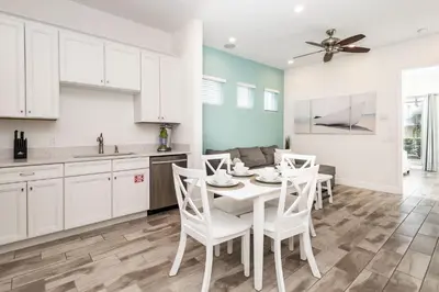 a kitchen with white cabinets and a white table and chairs at Up to Scale With Margaritas in Orlando