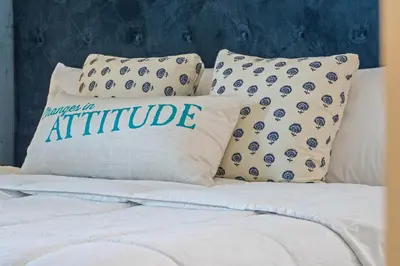 a bed with two pillows with the word attitude on it at Get Happy in Orlando