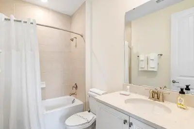 a bathroom with a sink and a toilet and a mirror at Turquoise Breeze - Close to Disney in Orlando