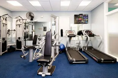 a gym with several tread machines in a room at Tranquil Breeze at Caribe Cove in Orlando