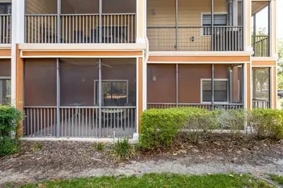 an apartment building with a fence in front of it at Tranquil Breeze at Caribe Cove in Orlando
