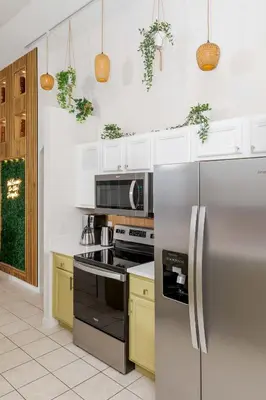 a kitchen with white cabinets and a stainless steel refrigerator at Jewel of Emerald Island with Heated Pool in Kissimmee