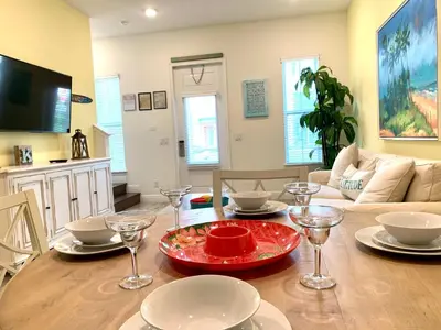 a dining room with a table with plates and wine glasses at Krows Nest - Near Disney World & Universal in Orlando