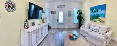 a living room with a couch and a flat screen tv at Krows Nest - Near Disney World & Universal in Orlando
