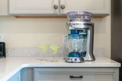 a blender sitting on top of a counter with two glasses at Lafitte's Landing Lakeview Cottage - Lakefront in Orlando