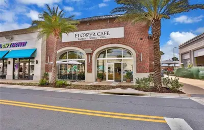 a building with palm trees in front of a store at Lafitte's Landing Lakeview Cottage - Lakefront in Orlando