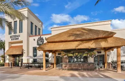 a restaurant with a large straw umbrella in front of a building at Lafitte's Landing Lakeview Cottage - Lakefront in Orlando